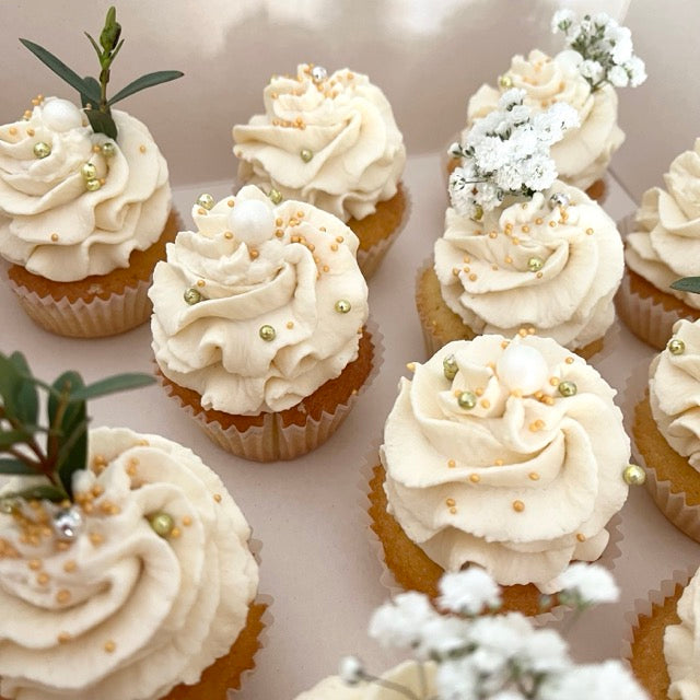 muffins avec une crème chantilly sur le dessus et des petites fleurs. pour un buffet de mariage. 